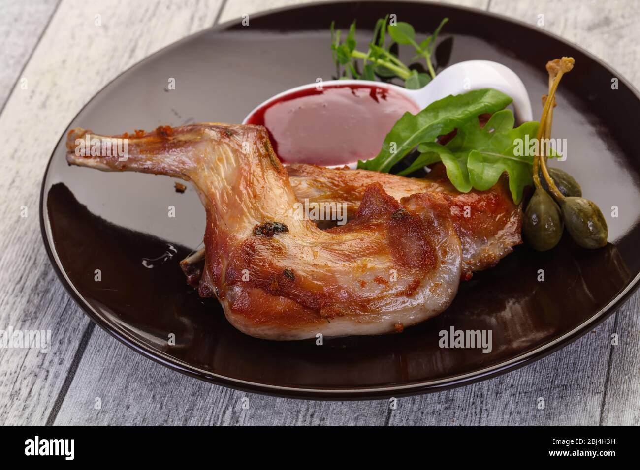 Roasted rabbit legs with cowberry sauce Stock Photo Alamy
