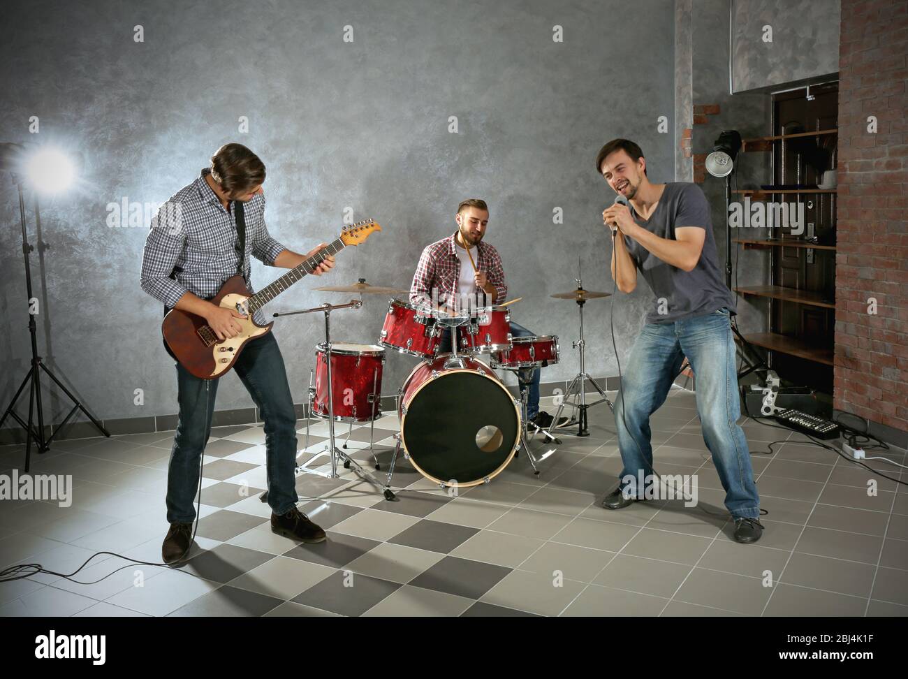 Musicians playing musical instruments and singing songs in a studio