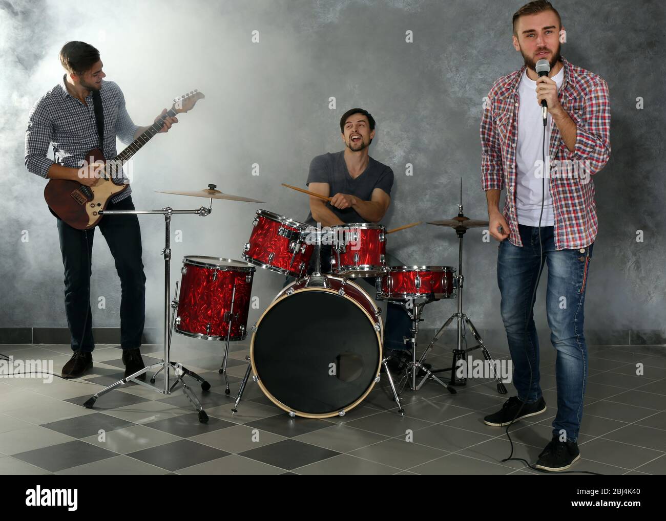 Musicians playing musical instruments and singing songs in a studio Stock Photo