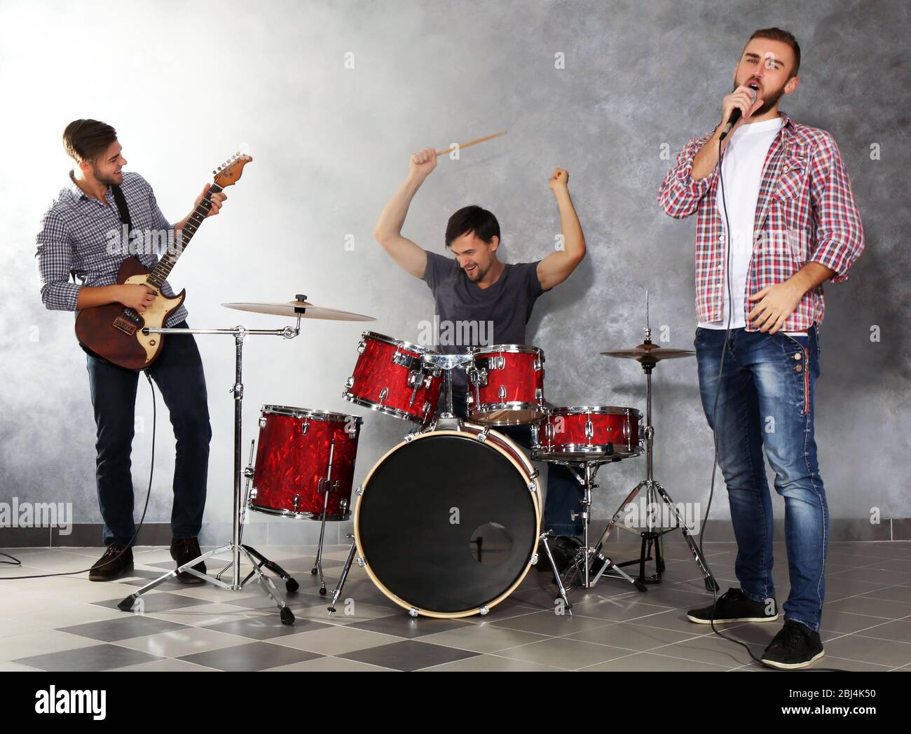 Musicians playing musical instruments and singing songs in a studio