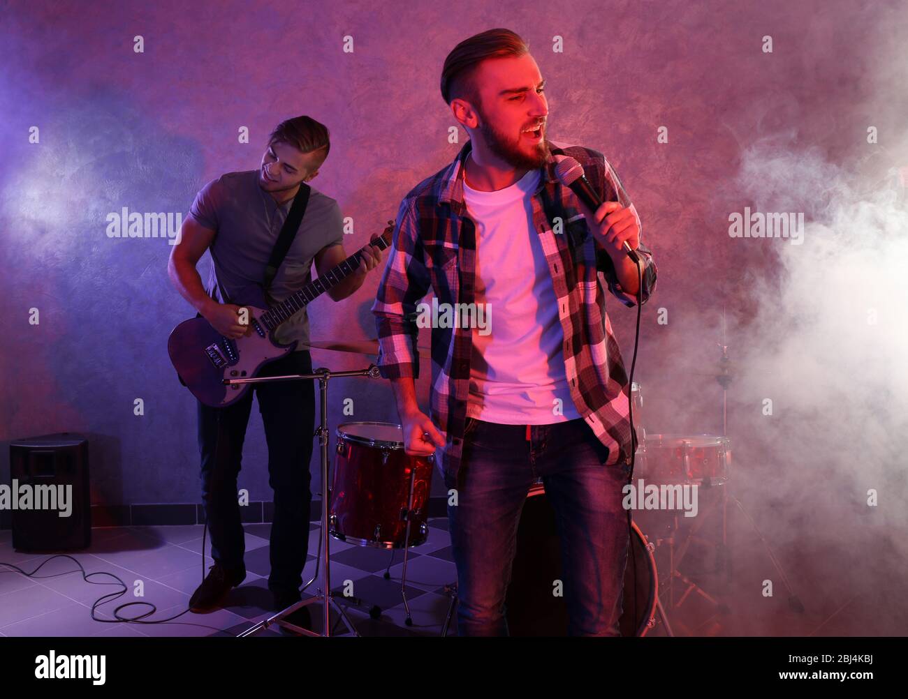 Musicians playing musical instruments and singing songs in a studio