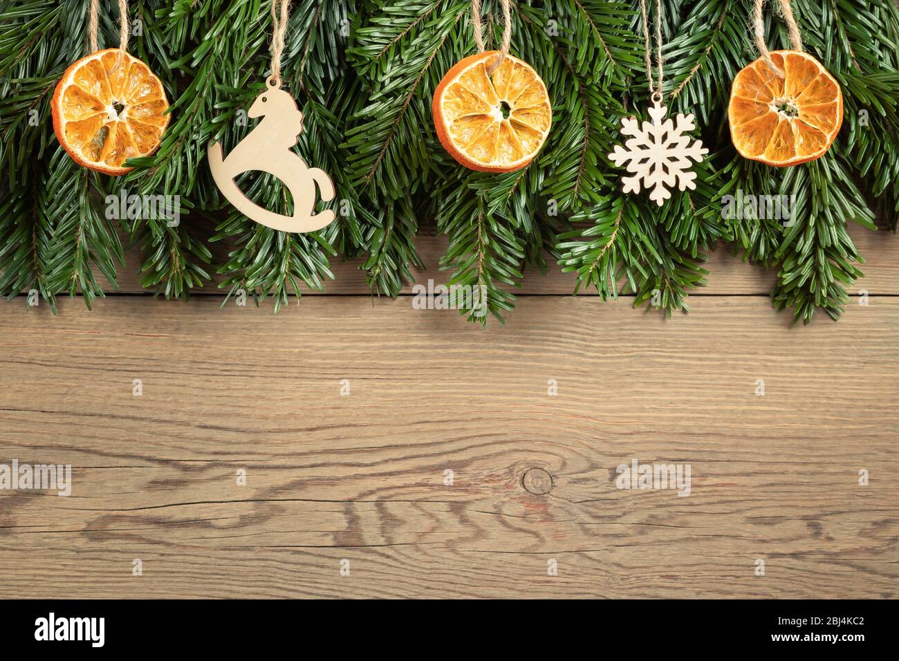 Zero waste and eco friendly christmas concept. Christmas tree branches with natural decorations on a wooden wall. Horizontal banner with copy space. Stock Photo