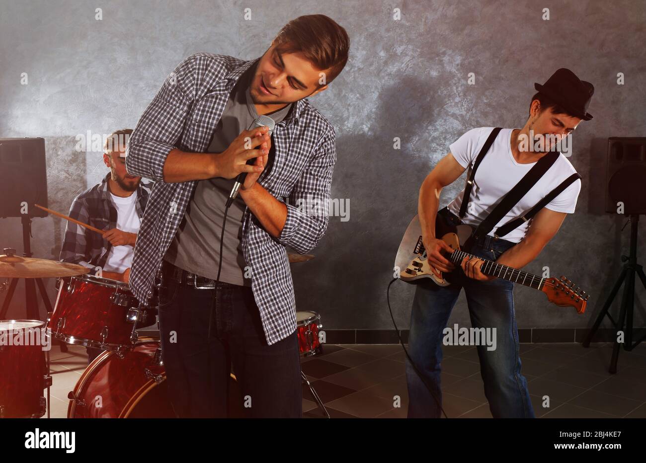 Musicians playing musical instruments and singing songs in a studio