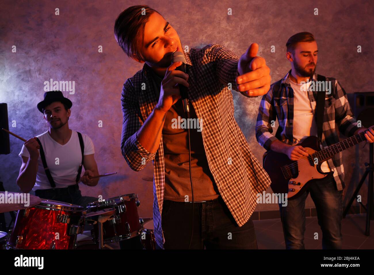 Musicians playing musical instruments and singing songs in a studio