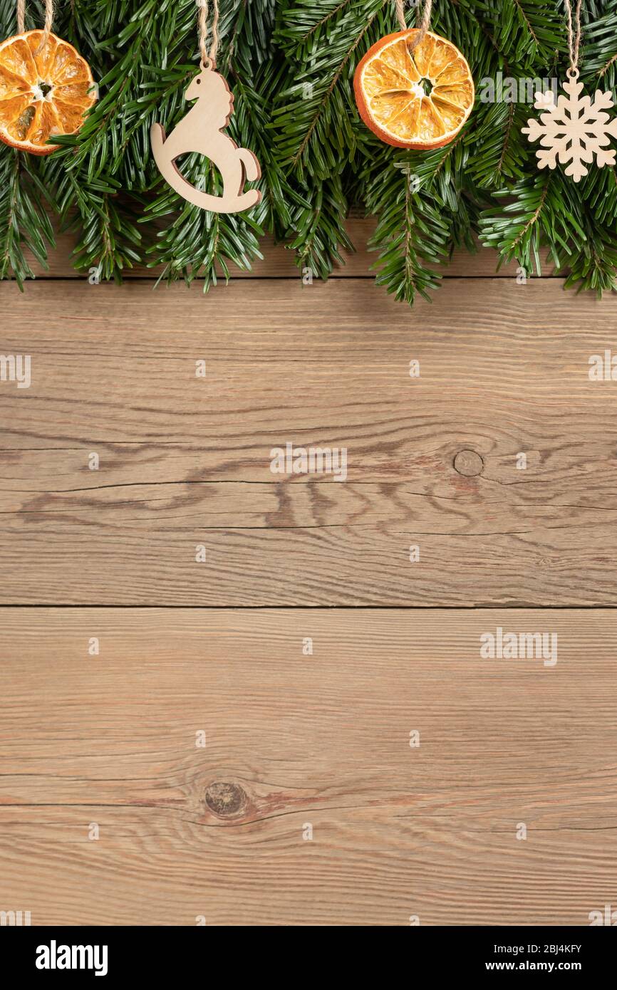Zero waste and eco friendly christmas concept. Christmas tree branches with natural decorations on a wooden wall. Vertical banner with copy space. Stock Photo