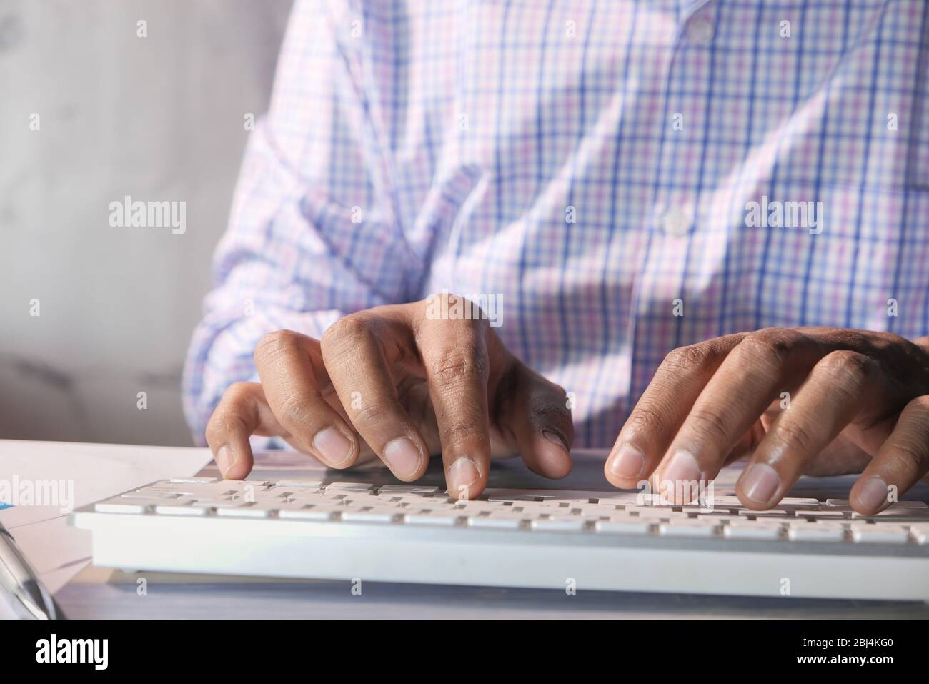 young man typing on keyboard in office Stock Photo