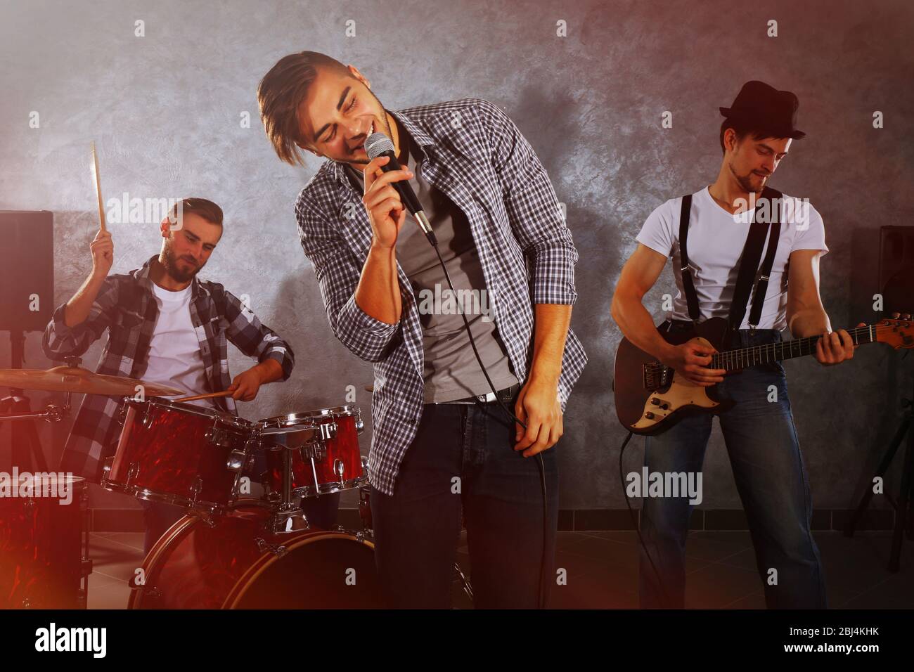 Musicians playing musical instruments and singing songs in a studio