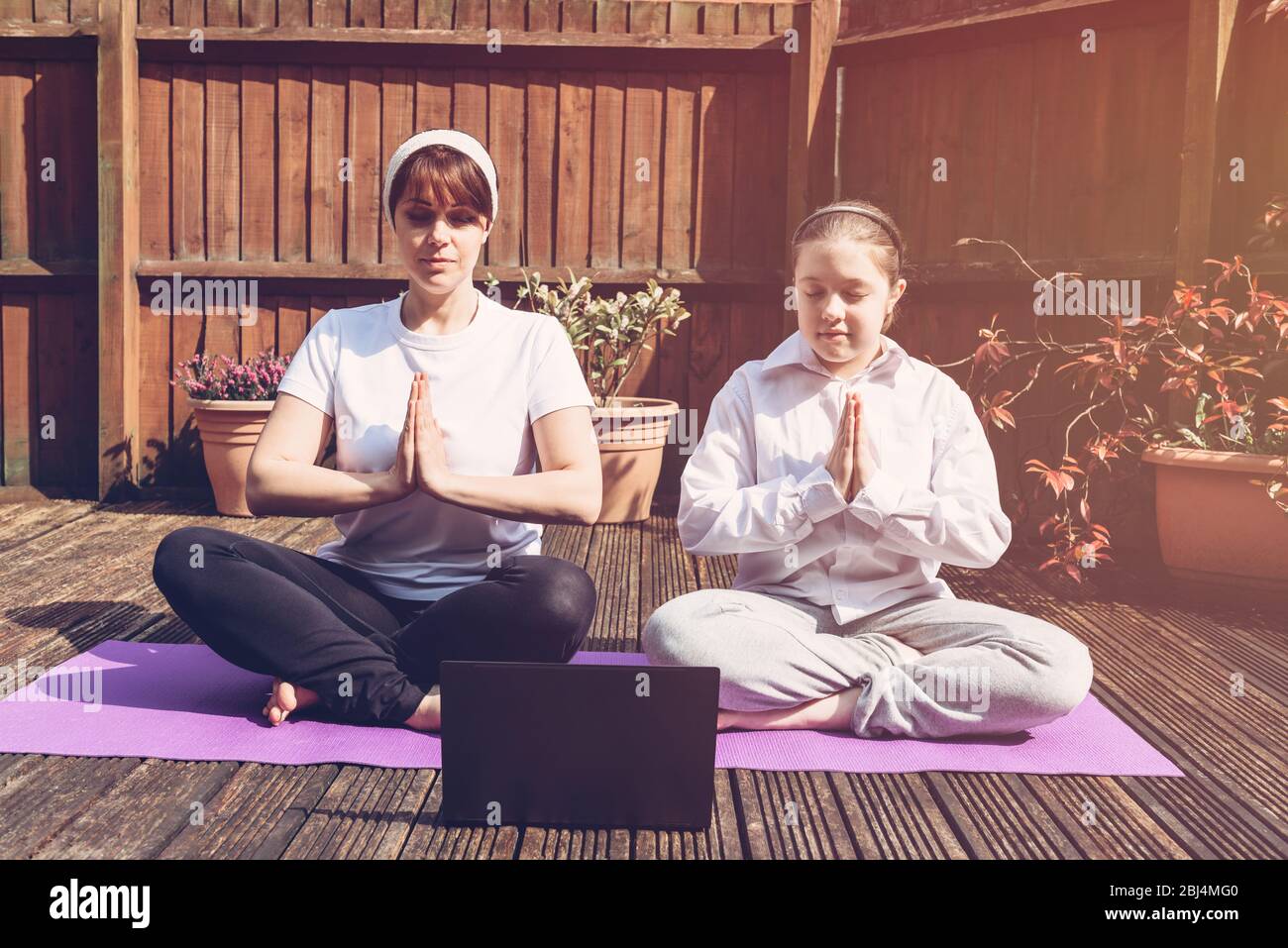 Happy Mother and Daughter are doing yoga Stock Photo