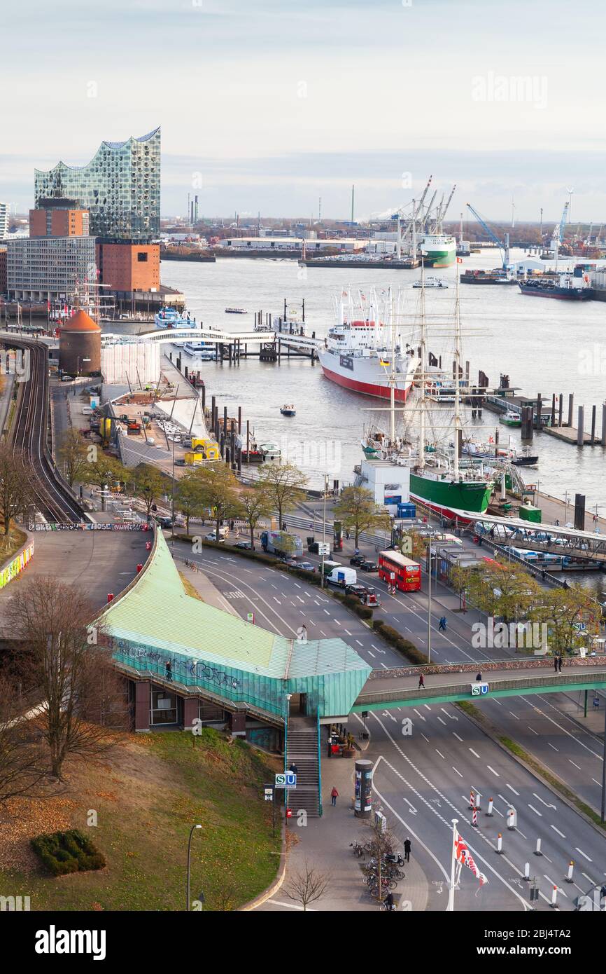 Hamburg, Germany - November 26, 2018: Port of Hamburg with moored ships at daytime, vertical photo. Ordinary people and cars are on the street. Aerial Stock Photo