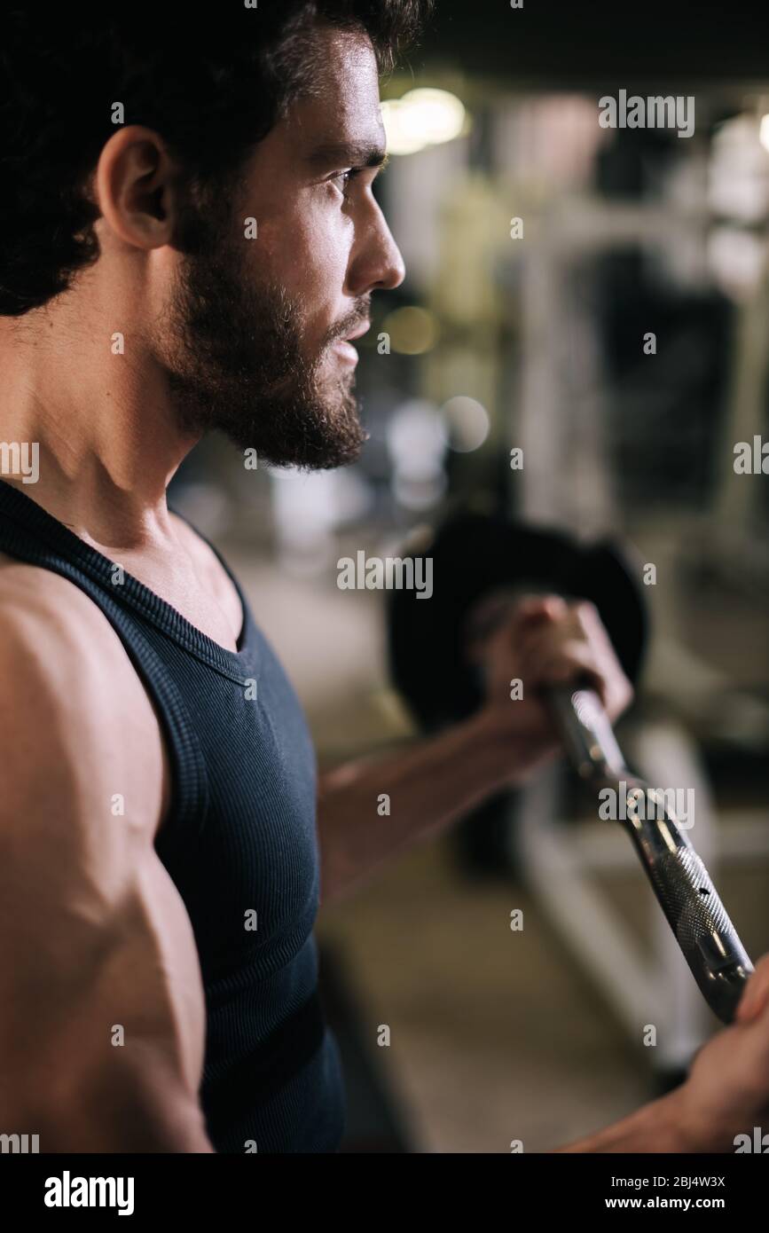 Close-up of face of handsome bearded young man with muscular wiry body