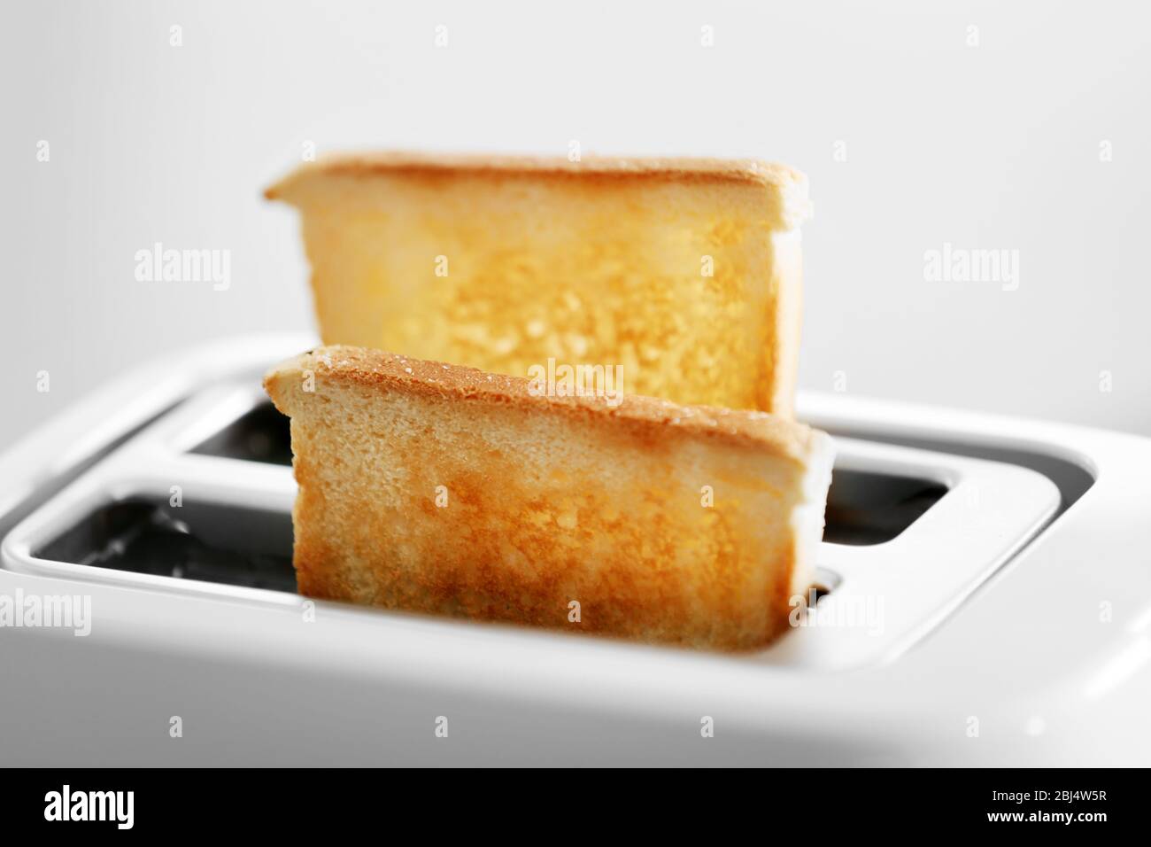 A couple of crusty toasts in the toaster, close-up Stock Photo - Alamy