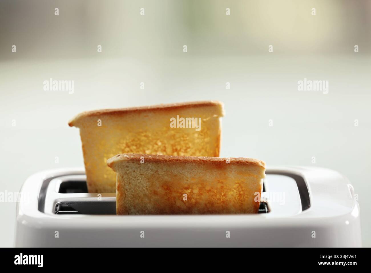 A couple of crusty toasts in the toaster, close-up Stock Photo - Alamy