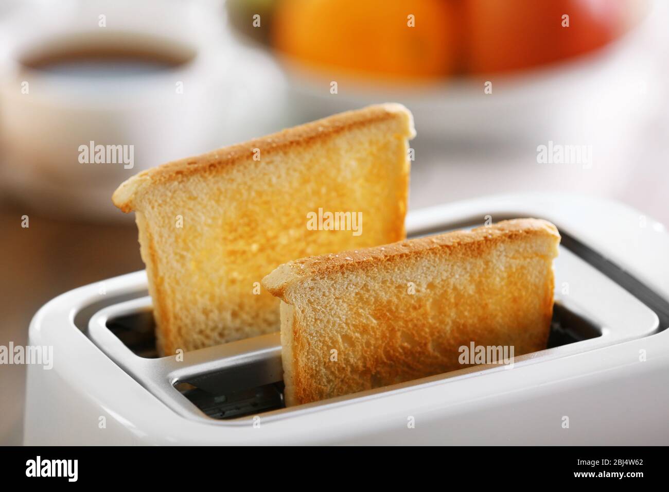 A couple of crusty toasts in the toaster, close-up Stock Photo - Alamy
