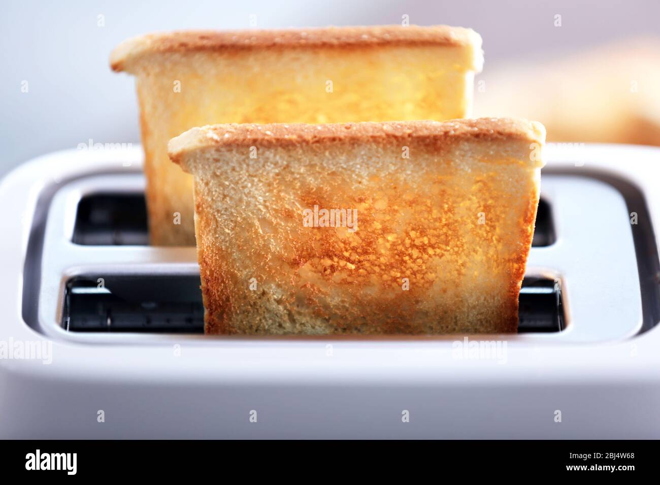 A couple of crusty toast in the toaster, close-up Stock Photo - Alamy