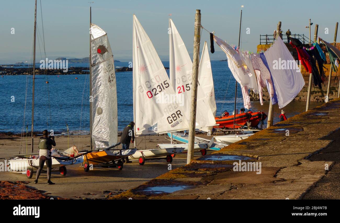 Sailing Dinghies, preparing for club racing, and washing line on Low Quay, The Harbour, North Berwick Stock Photo