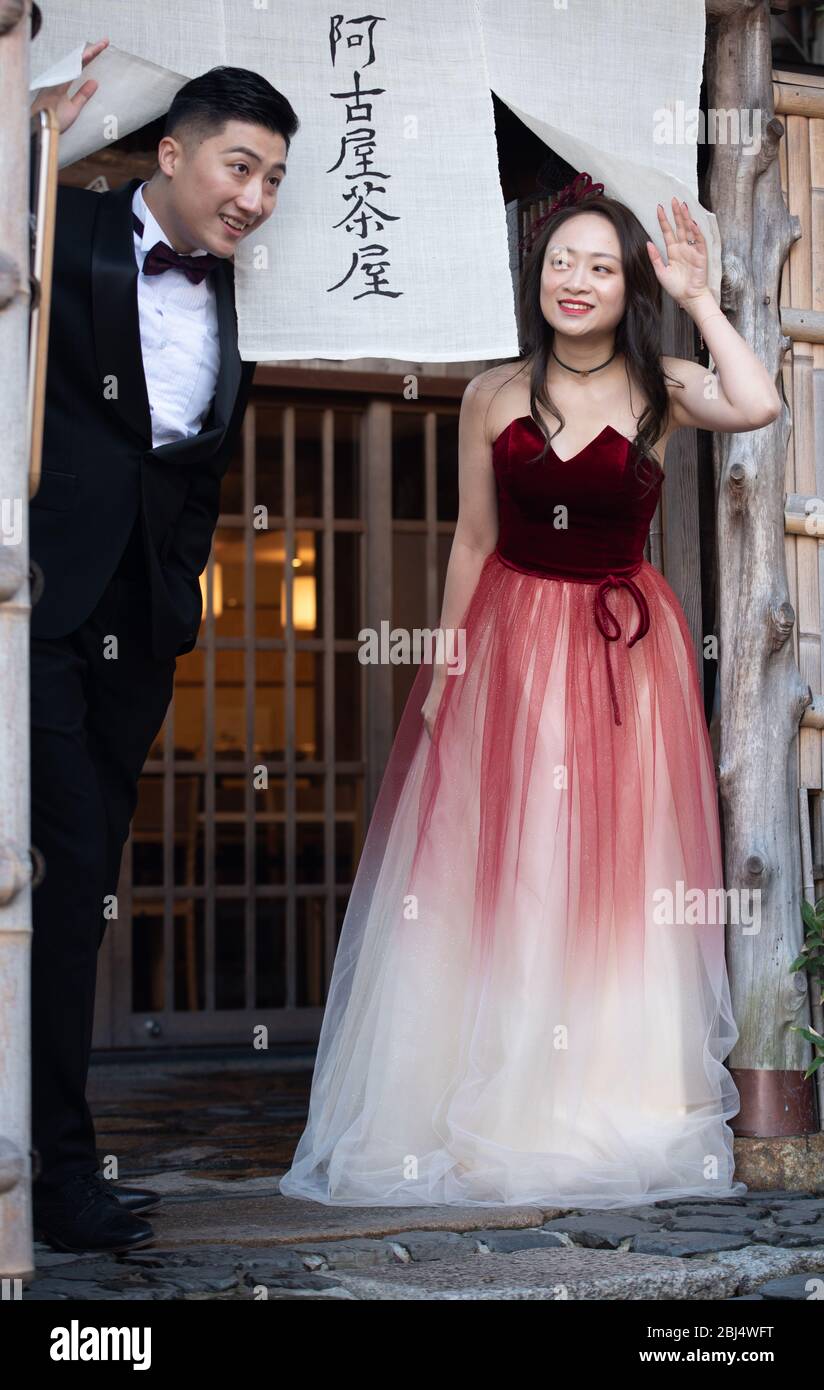 A couple at Kyoto's Sannenzaka street waving hello to passers by and family. They came  to celebrate their engagement, Stock Photo