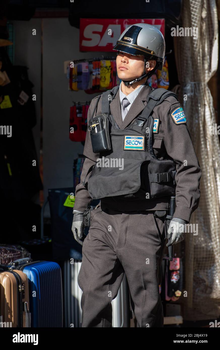 A policeman on foot patrol at the Ameyoko market, Tokyo, Japan Stock Photo