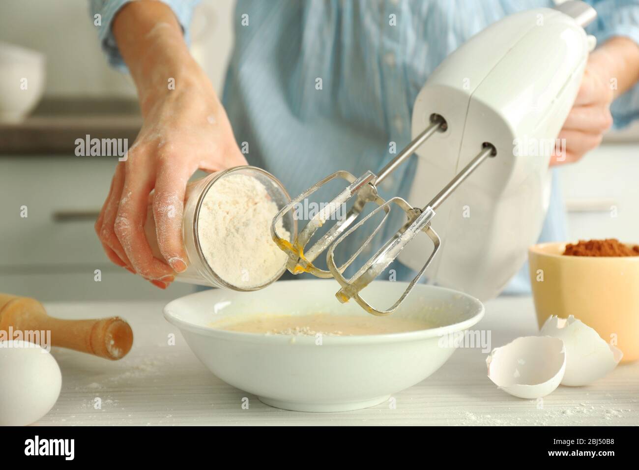 Woman adding flour mixture hi-res stock photography and images - Alamy