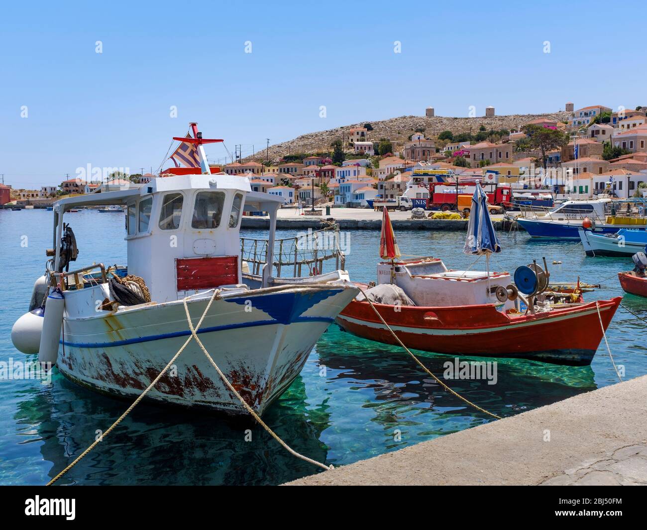 White and red fishing boats in Halki harbour. Stock Photo