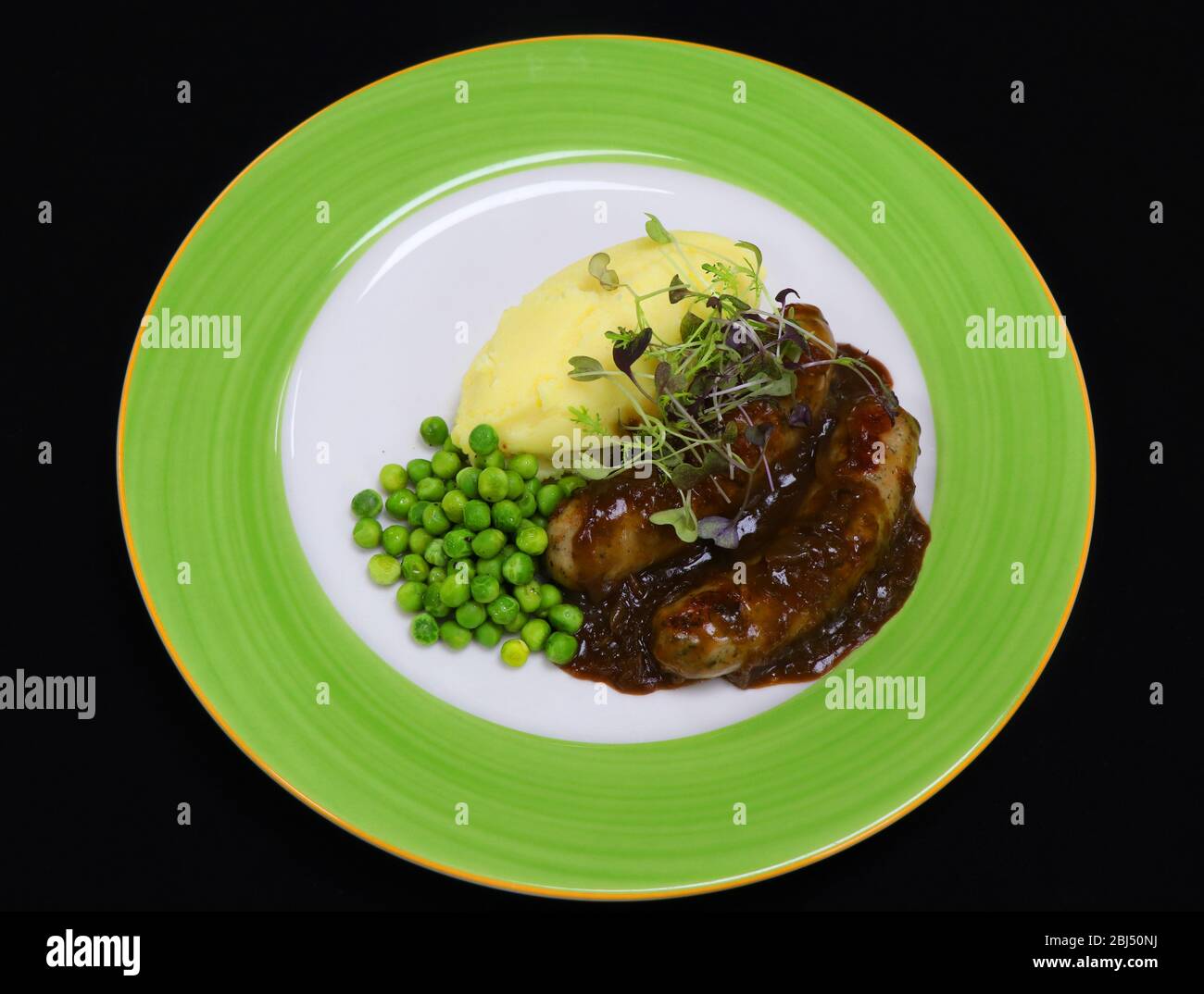 bangers and mash with onion gravy and green peas Stock Photo Alamy