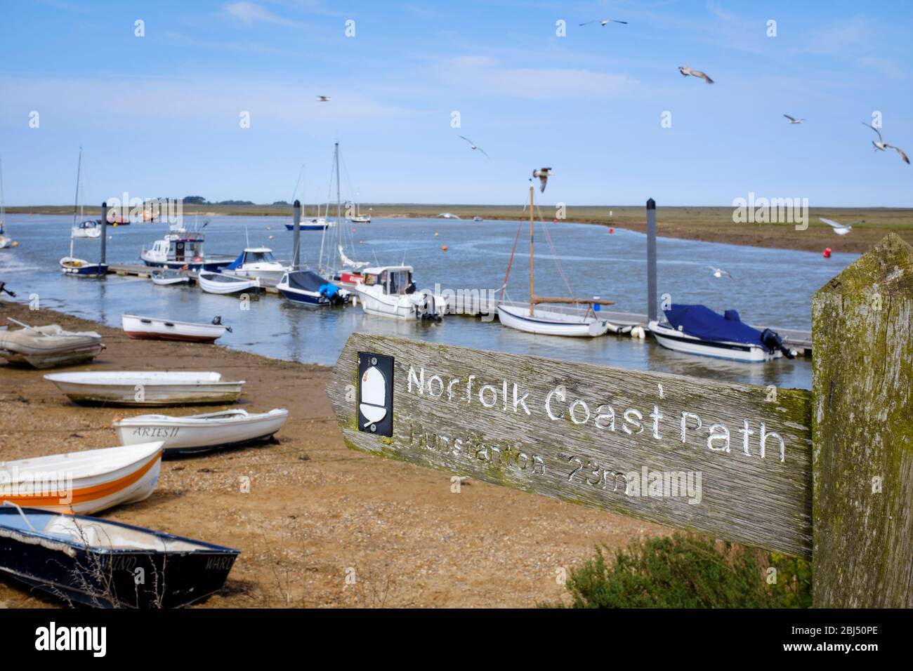 Norfolk Coast Path sign with boats in the background at Wells-Next-The-Sea. Stock Photo