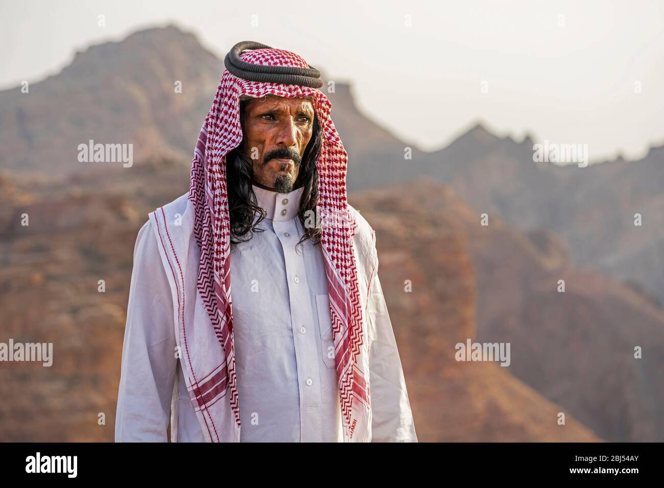 A Bedouin man looks out across his mountainous desert home in Jordan. Stock Photo