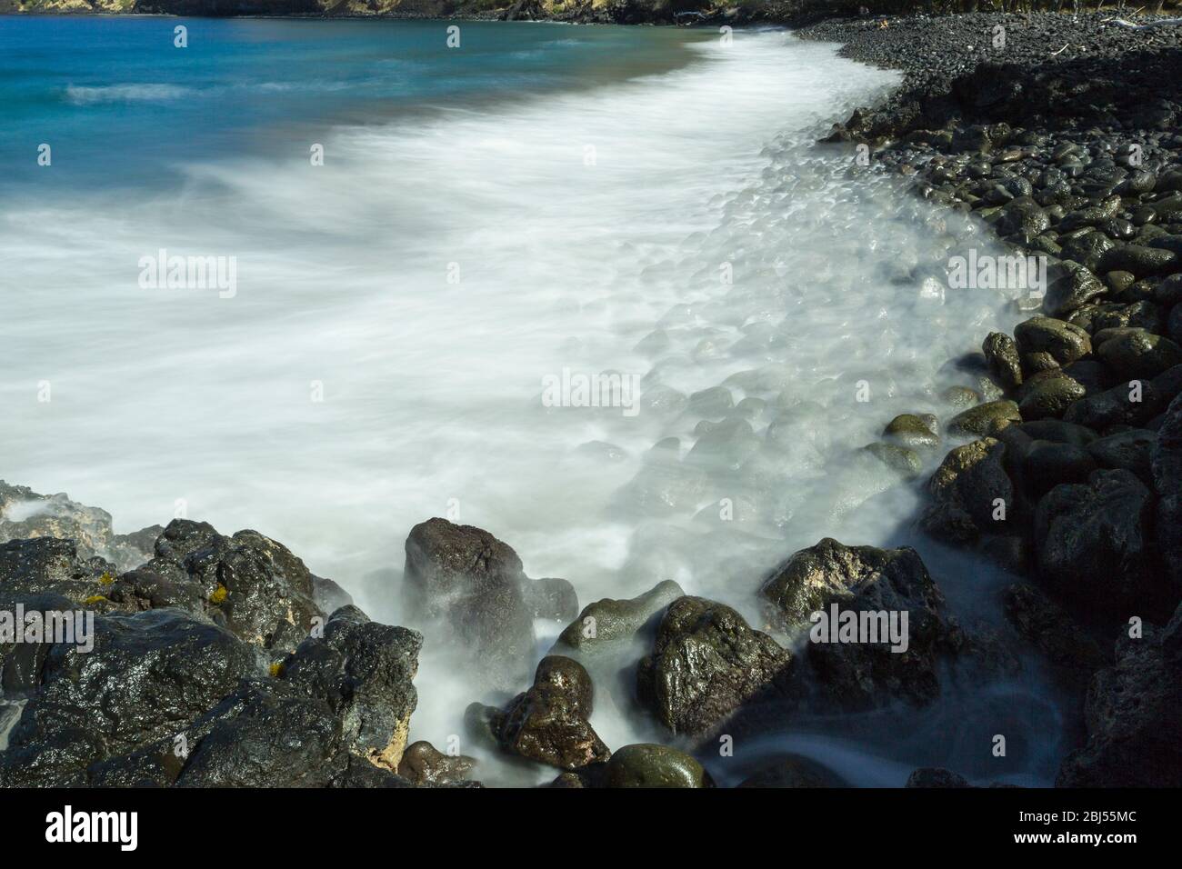 Time exposure of surf on rocky beach at Napoopoo, Hawaii Stock Photo