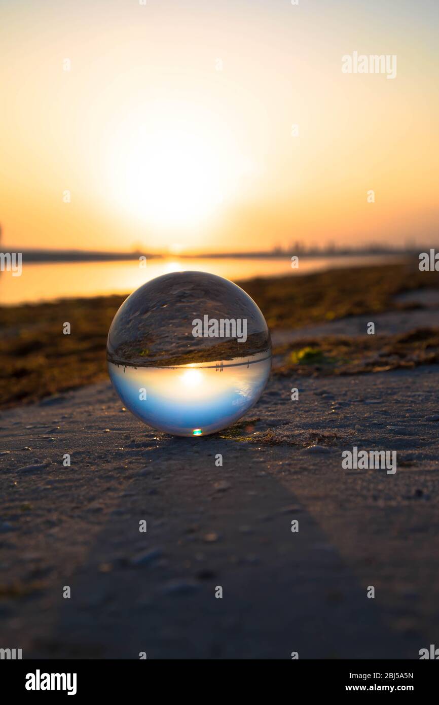Sunset on a beach through a crystal ball Stock Photo - Alamy