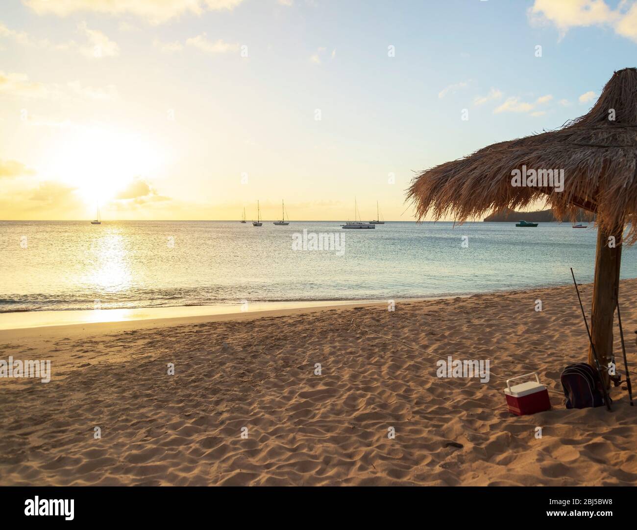 the sun is near the horizon, it about to get dark, fishing gear on the beach and no sign of the fisherman anywhere Stock Photo