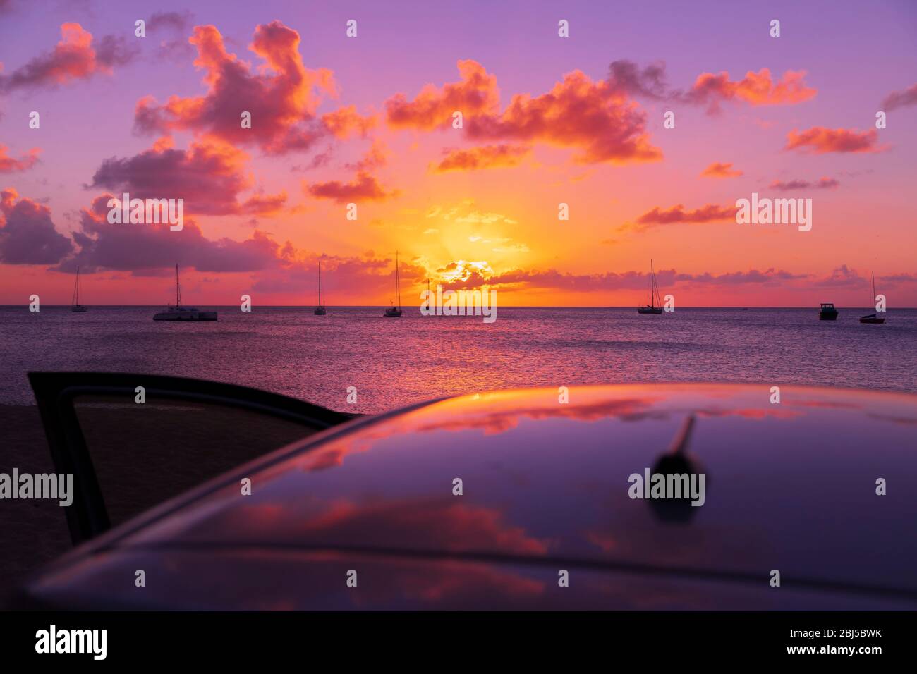 tropical sunset reflection on car roof with the door opened Stock Photo