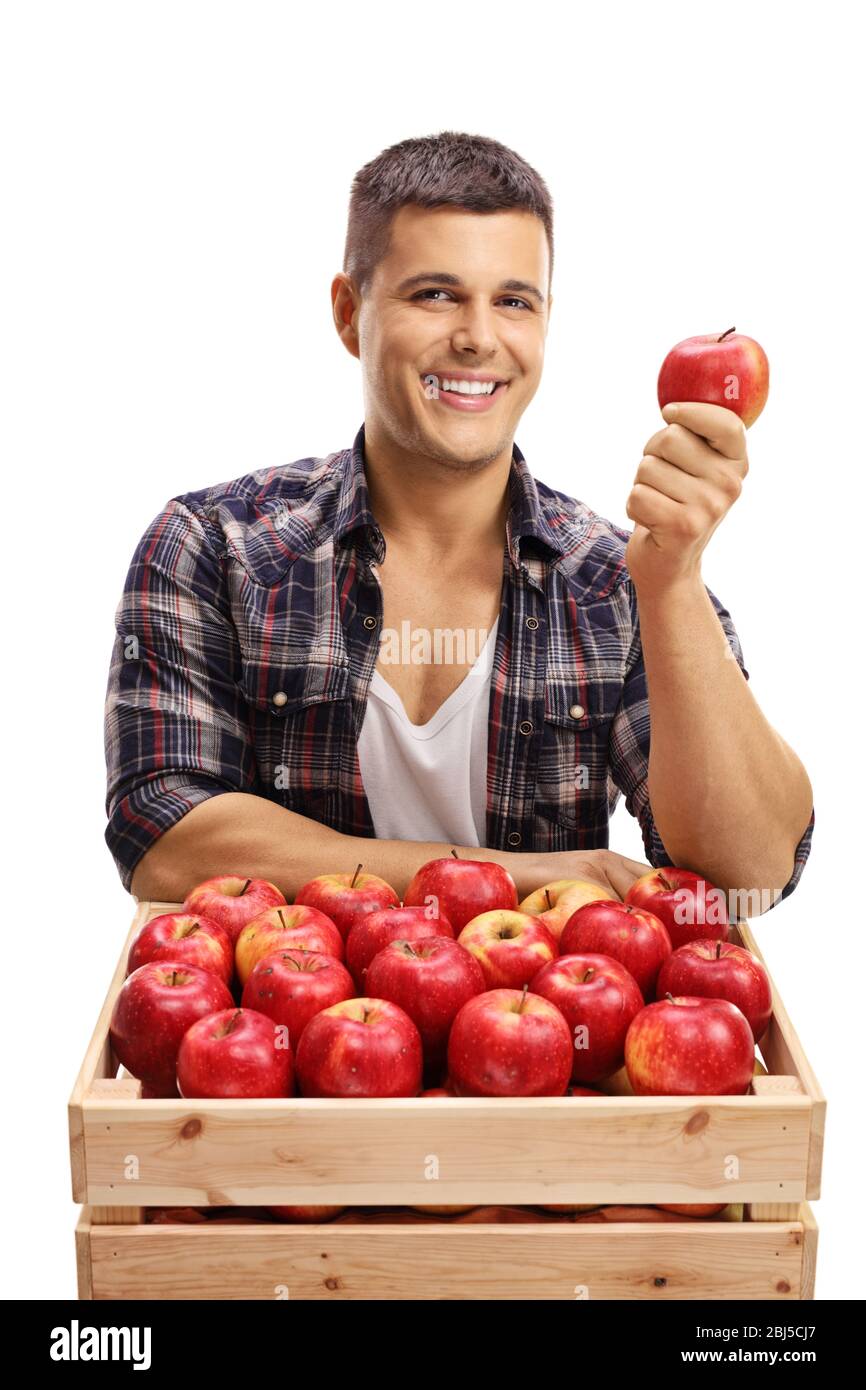 Handsome young male farmer with a crate full of red apples isolated on ...