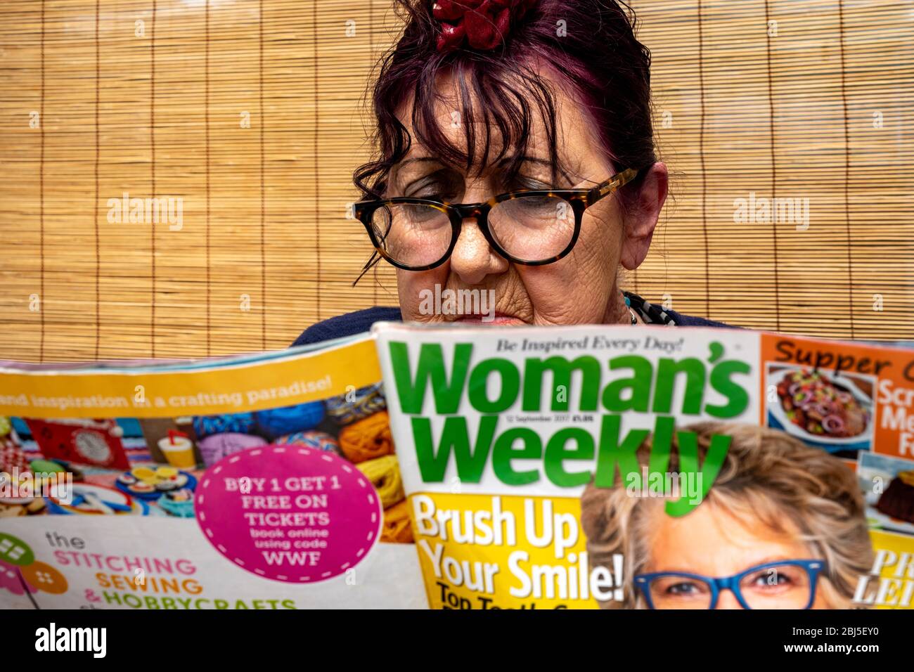 Elderly woman reading Woman's Weekly magazine Stock Photo