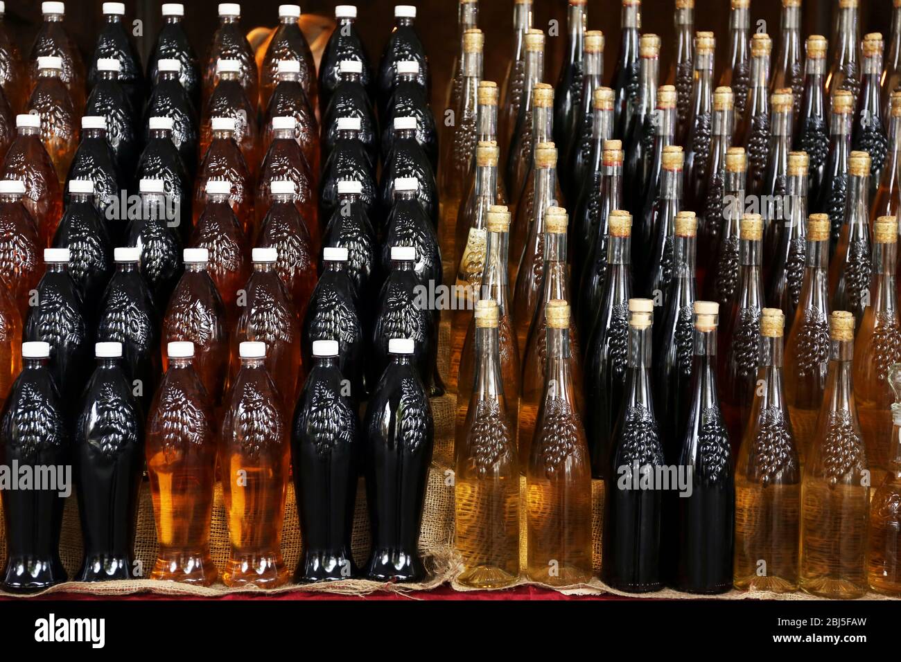 Red wine in bottles arranged in rows Stock Photo - Alamy