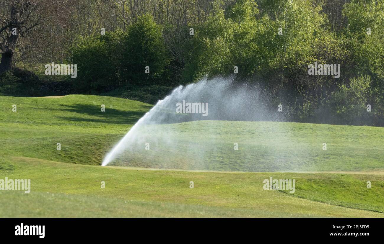 An irrigation system watering a golf course Stock Photo Alamy
