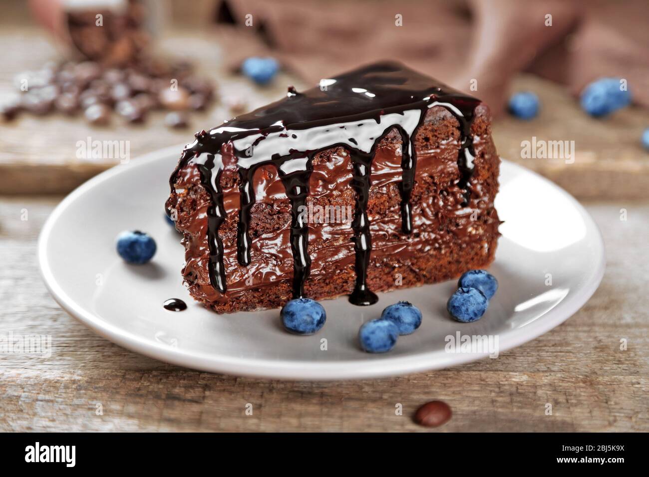 Chocolate cake with chocolate cream and fresh blueberries on plate, on ...