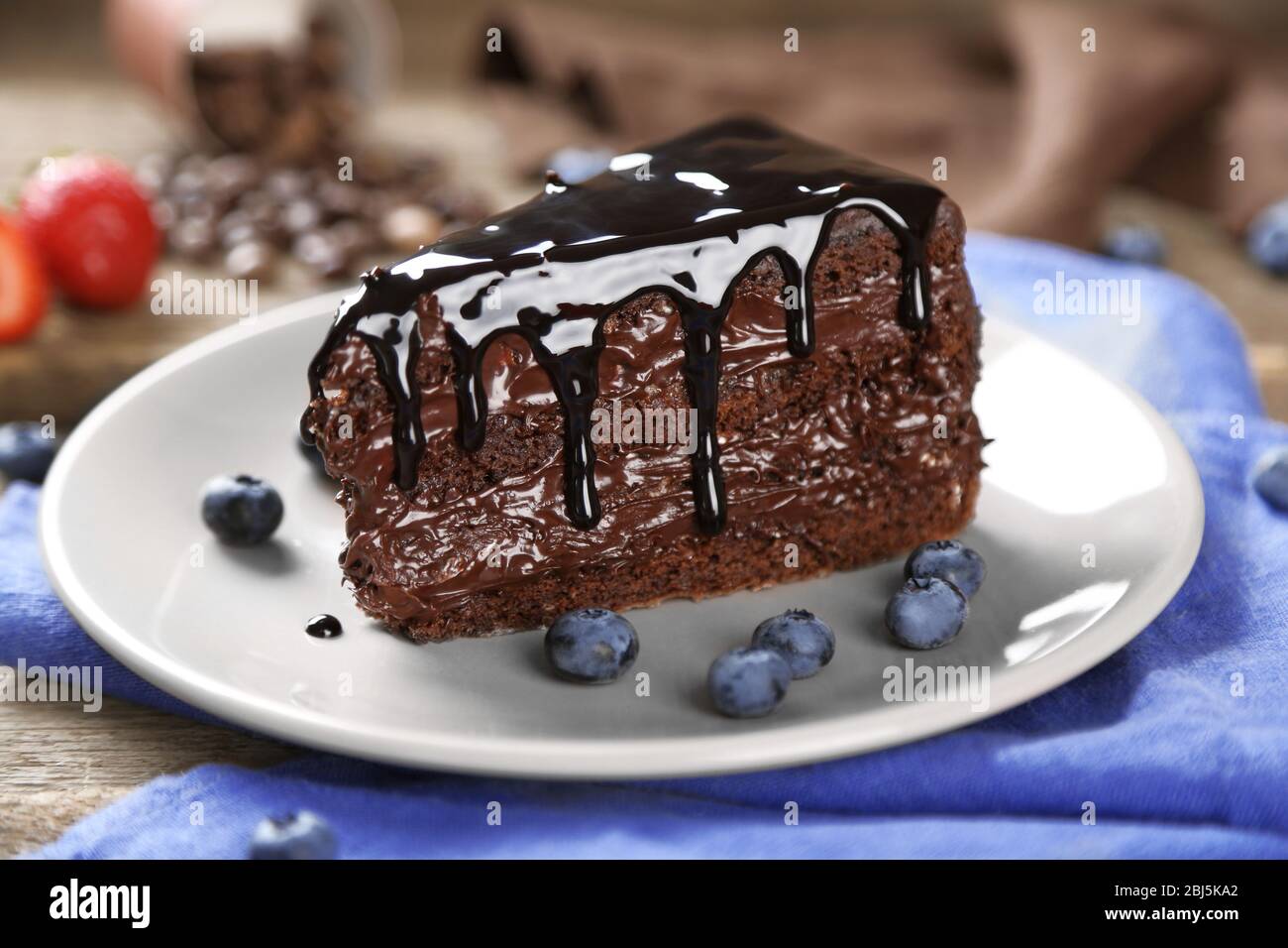 Chocolate cake with chocolate cream and fresh blueberries on plate, on ...