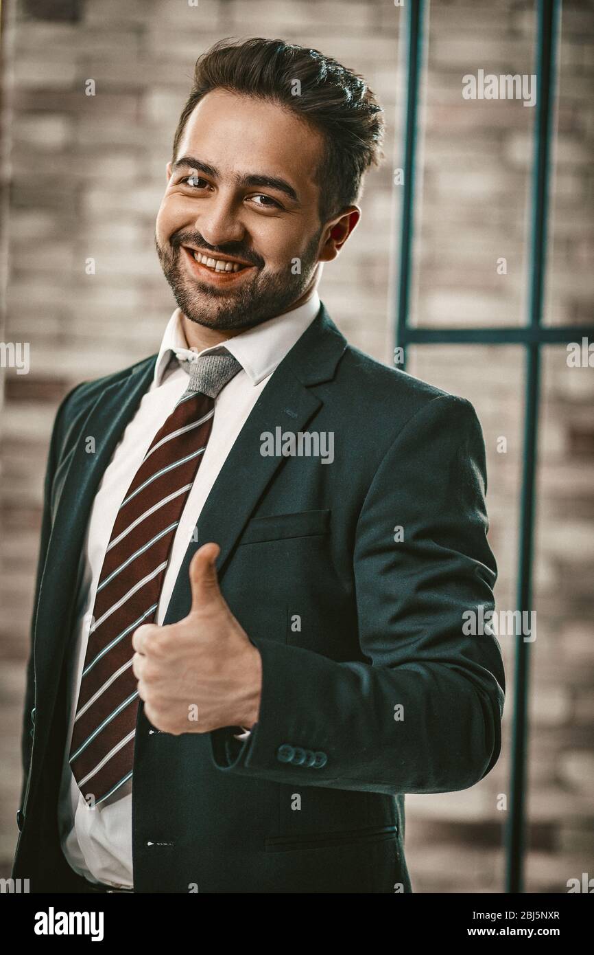 Handsome Man In Suite Shows Thumb Up In Office Stock Photo