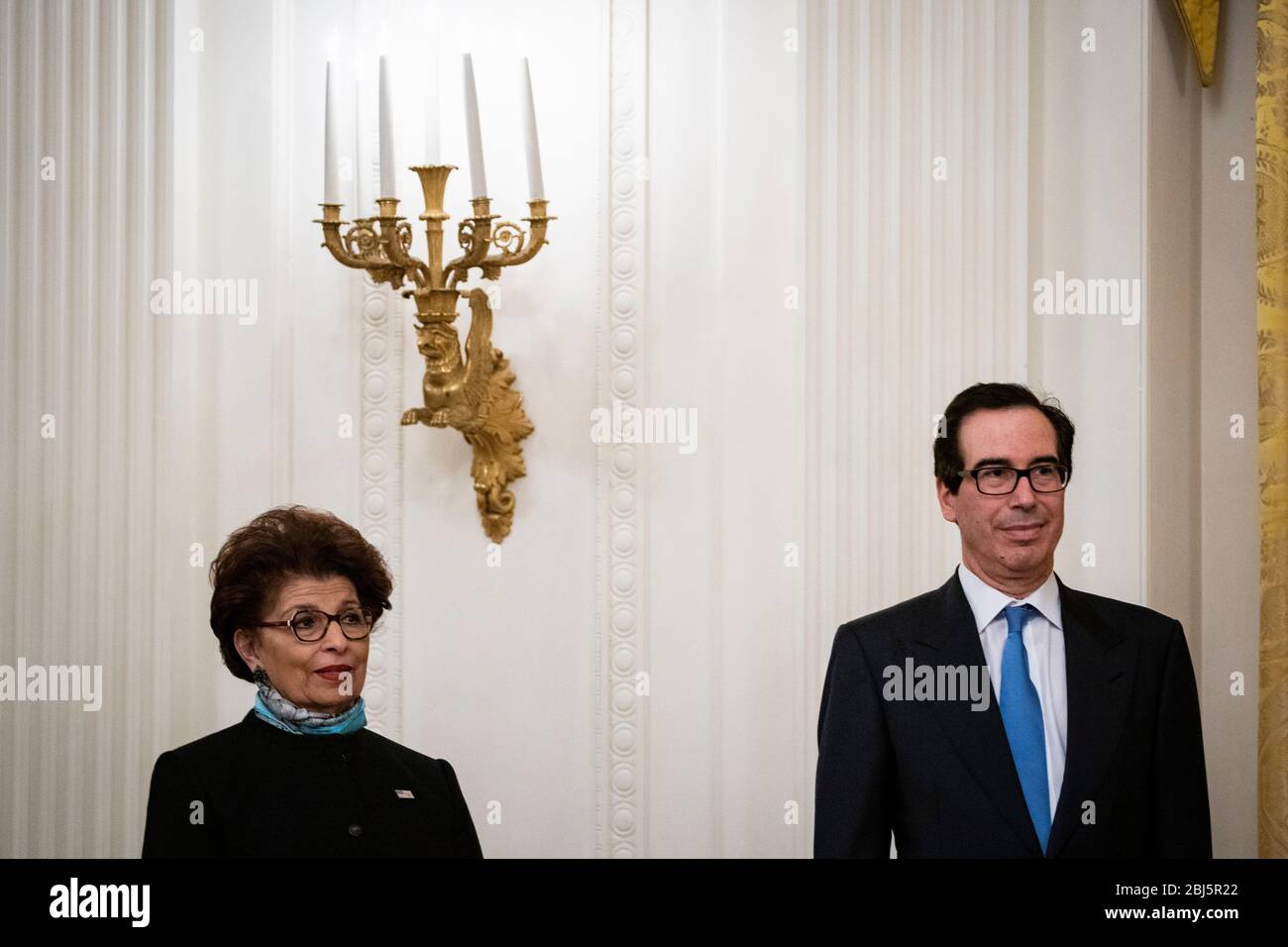 Jovita Carranza, administrator of the United States Small Business Administration (SBA), and United States Secretary of the Treasury Steven T. Mnuchin, listen during a Paycheck Protection Program (PPP) event in the East Room of the White House in Washington, DC, U.S., on Tuesday, April 28, 2020. US President Donald J. Trump defended his early, dismissive response to the coronavirus outbreak, saying Tuesday that he was told late in February that it wouldn't be a problem. Credit: Al Drago/Pool via CNP/MediaPunch Stock Photo