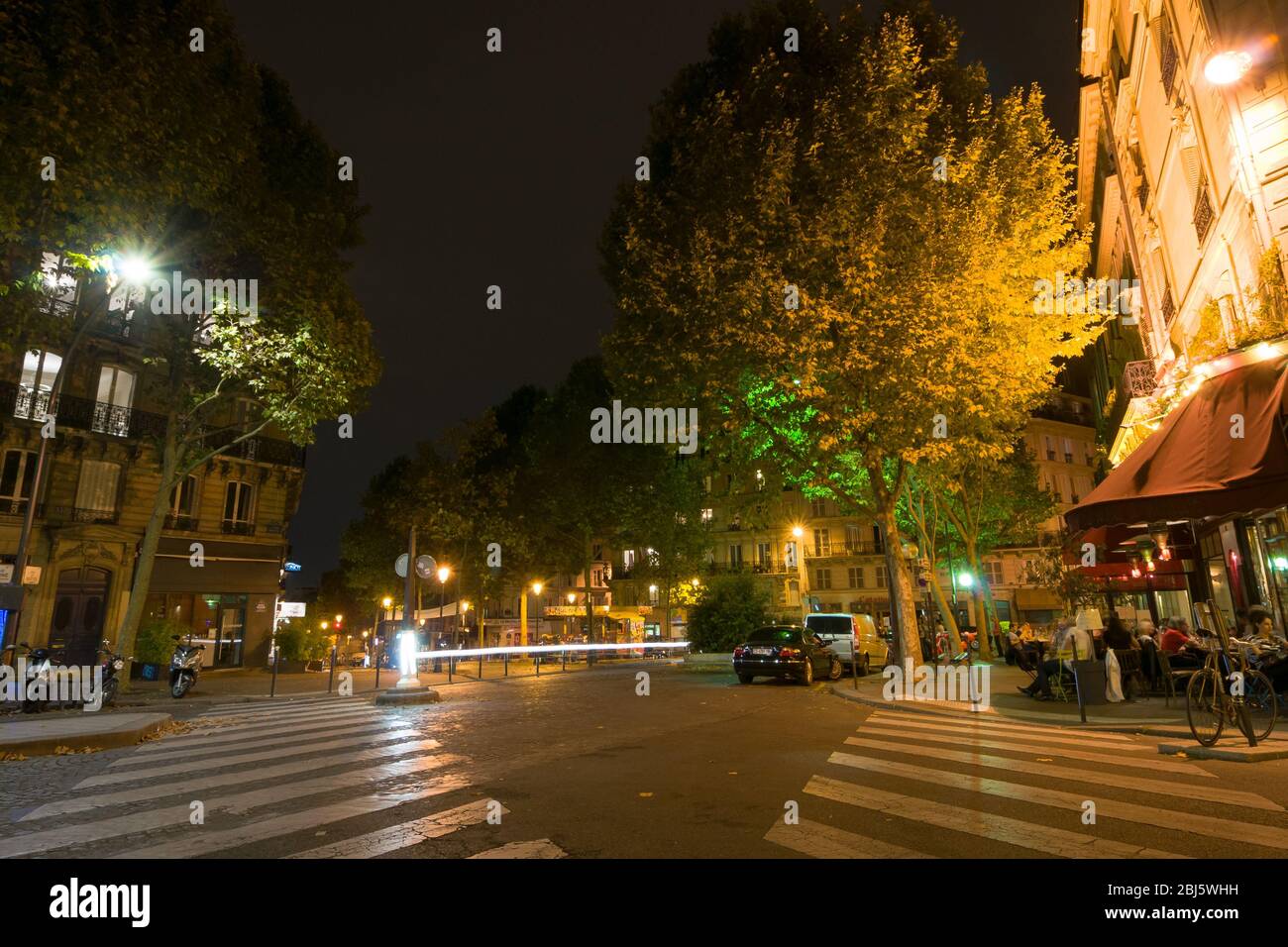 PARIS - SEPT 17, 2014: Paris by night. The people sit and talk in a cafe. Paris, France. Stock Photo