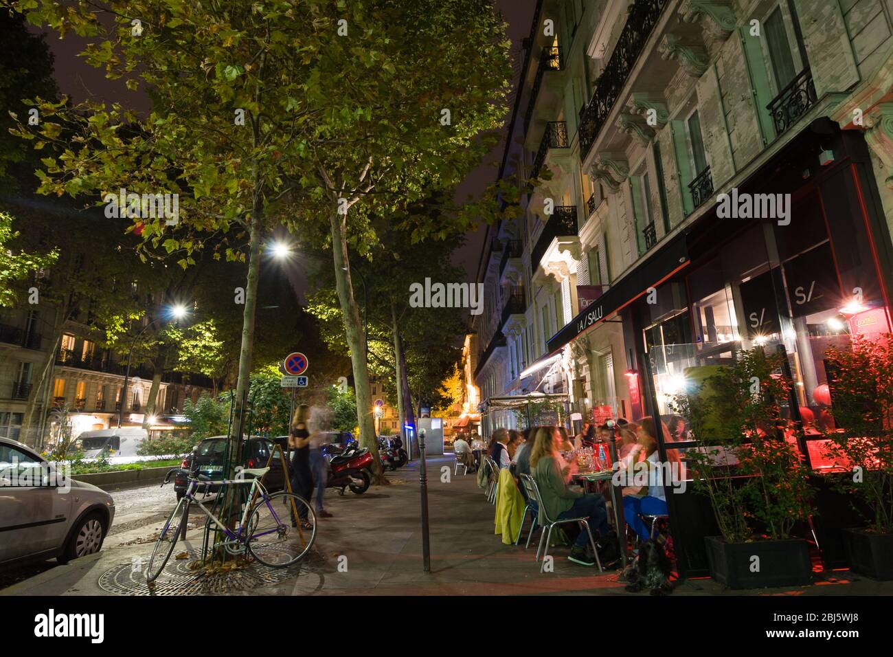 PARIS - SEPT 17, 2014: Paris by night. The people sit and talk in a cafe. Paris, France. Stock Photo