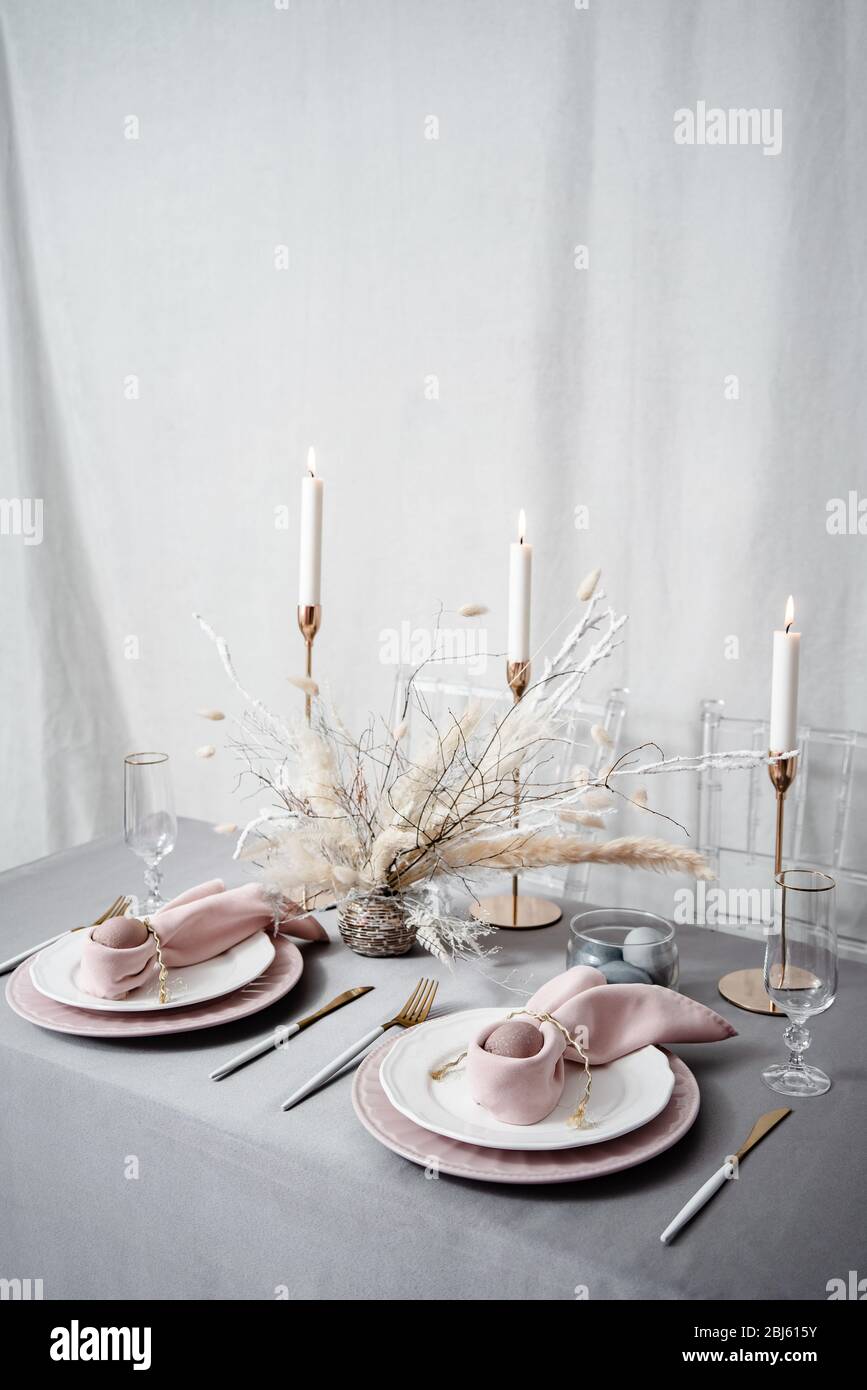 Setting easter table with candles and colored eggs Stock Photo