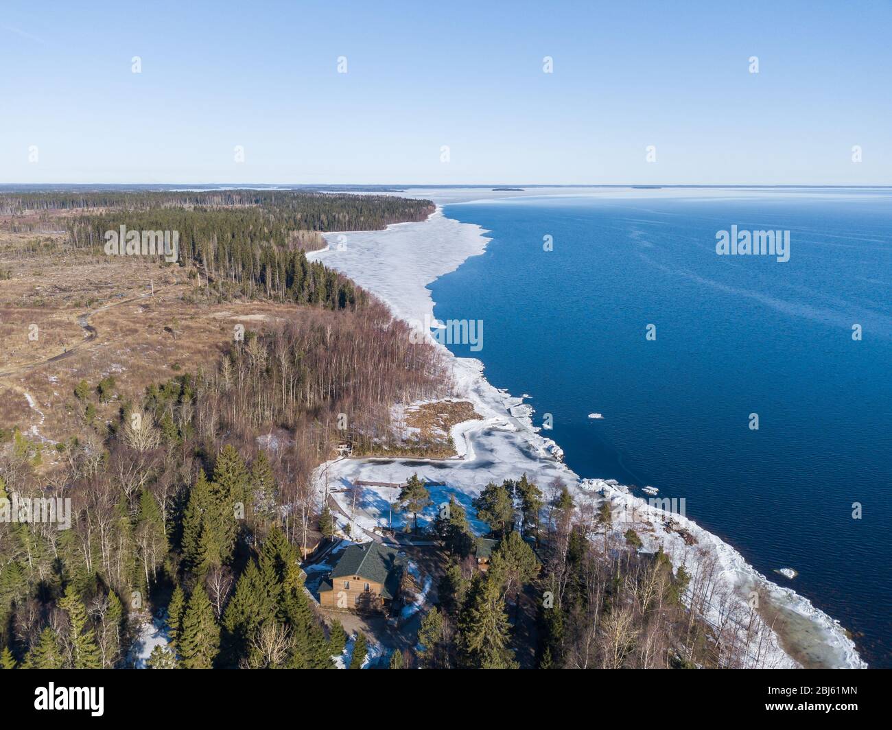 Aerial view of the shoreline of the lake and pieces of melting ice along the shore Stock Photo