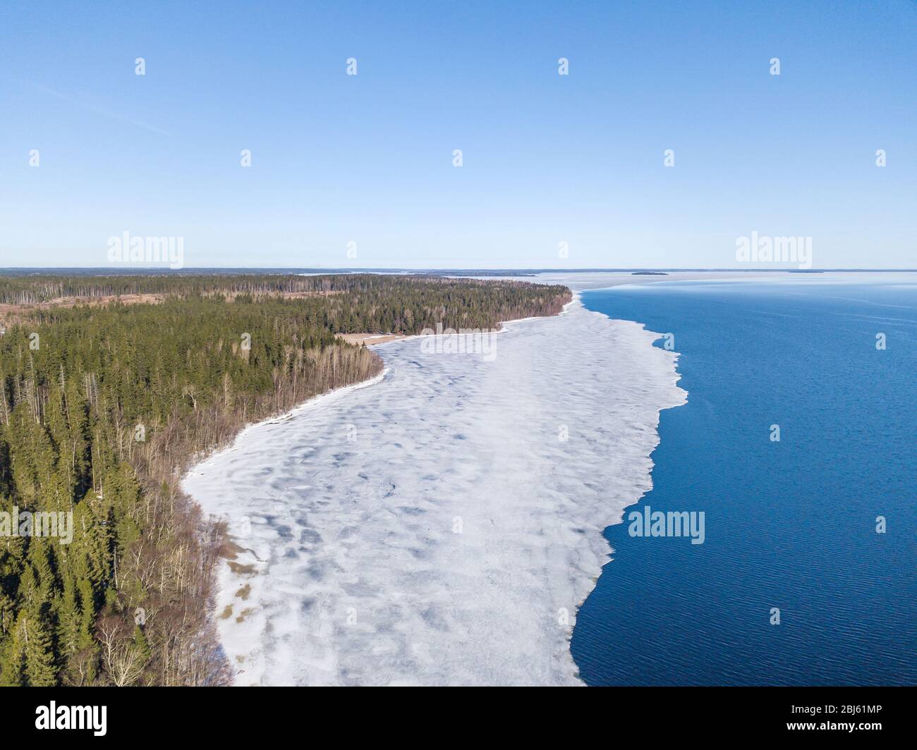 Aerial view of the shoreline of the lake and pieces of melting ice along the shore Stock Photo