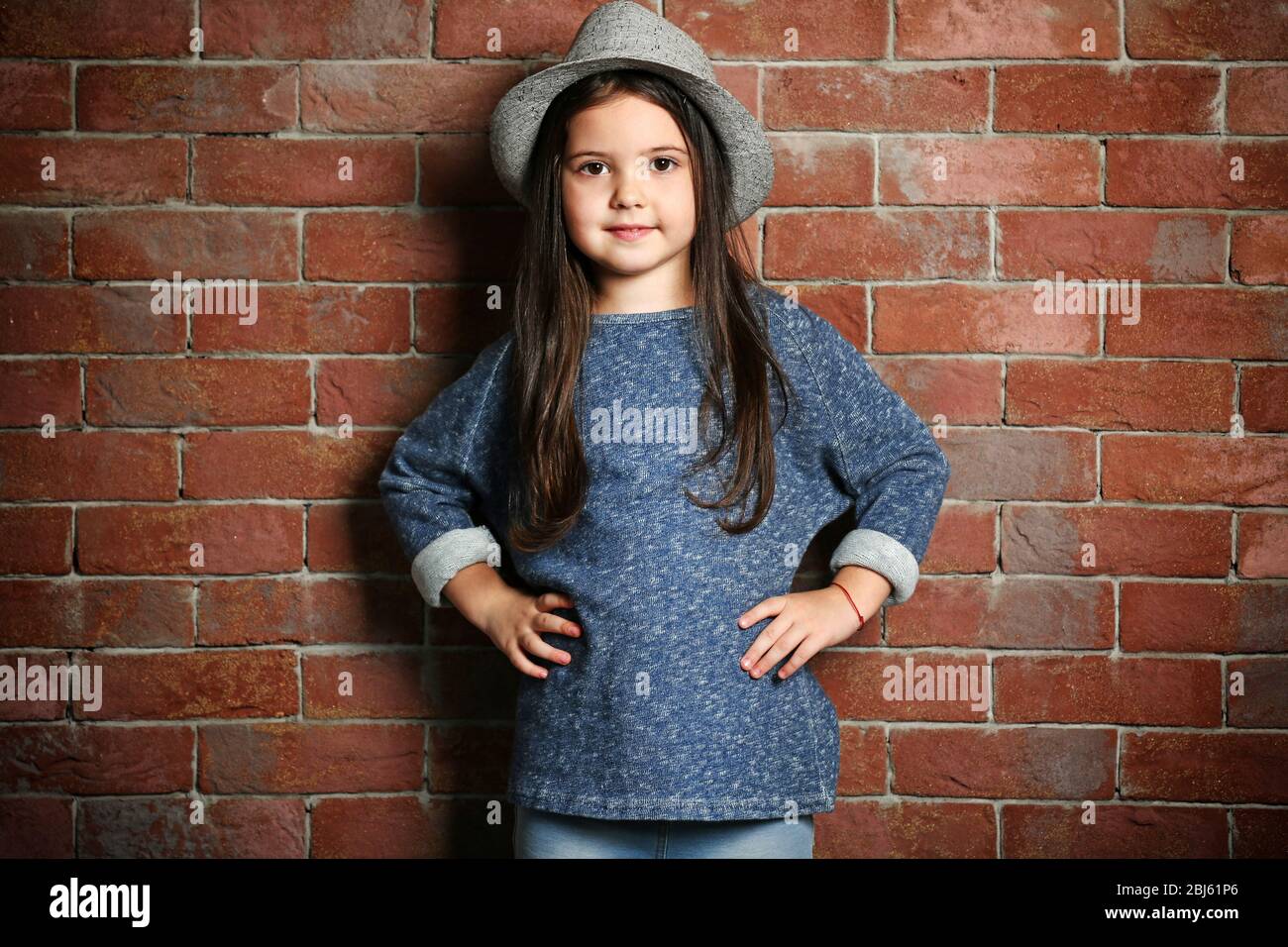 portrait-of-little-fashion-kid-girl-on-bricks-wall-background-stock