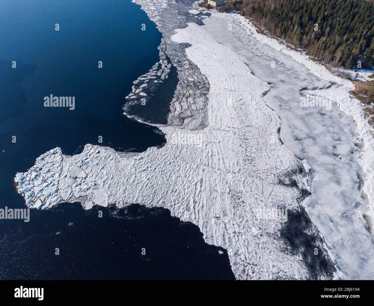 Aerial view of the shoreline of the lake and pieces of melting ice along the shore Stock Photo