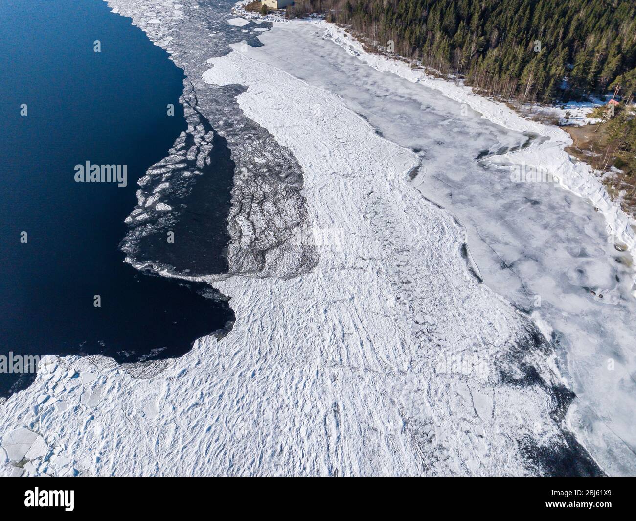 Aerial view of the shoreline of the lake and pieces of melting ice along the shore Stock Photo