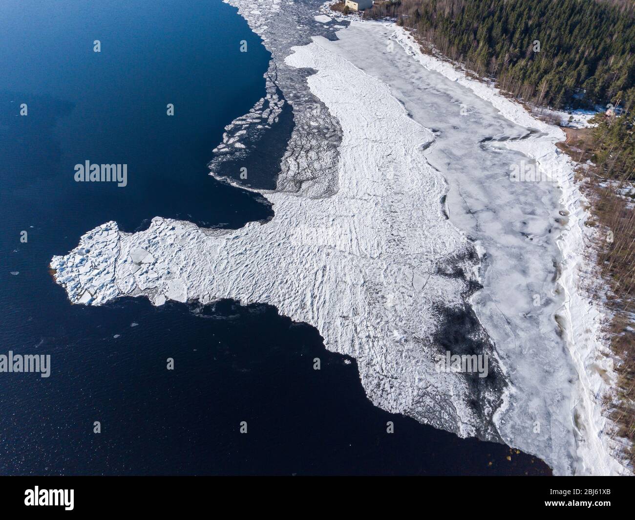 Aerial view of the shoreline of the lake and pieces of melting ice along the shore Stock Photo