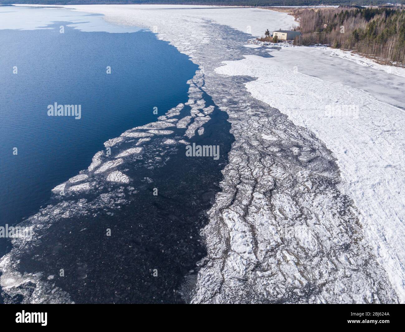Aerial view of the shoreline of the lake and pieces of melting ice along the shore Stock Photo