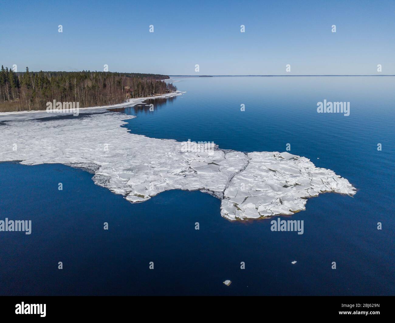 Aerial view of the shoreline of the lake and pieces of melting ice along the shore Stock Photo