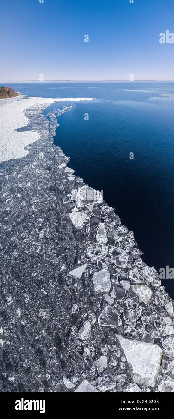 Aerial view of the shoreline of the lake and pieces of melting ice along the shore Stock Photo